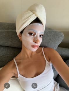A relaxed sheet-mask moment with a towel-wrapped hairstyle